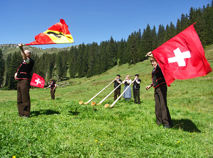 3 Alphornbläser mit Fahnenschwinger / Foto: Heinz Rieder